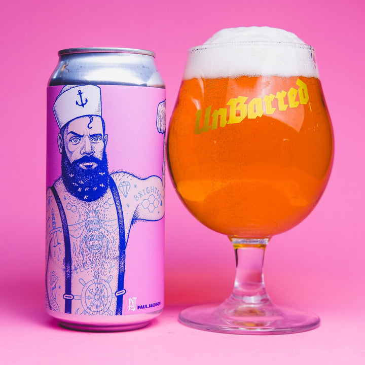 Can of Brighton Strong Belgian ale beside a glass of golden beer with a foamy head, highlighting a honey-infused Belgian ale with fruity, floral, and gently spiced character.